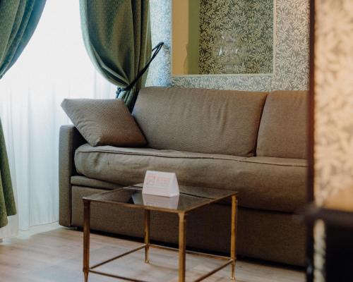 a living room with a couch and a table at Hotel Le Grimaldi by Happyculture in Nice