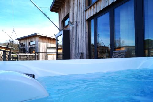 a hot tub in front of a house at Écolodges du Golf du Sauternais in Saint-Loubert