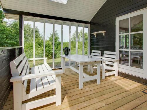 eine Veranda mit einem weißen Tisch und Stühlen darauf in der Unterkunft Holiday Home Gaetana - 1-6km from the sea in NE Jutland by Interhome in Hals