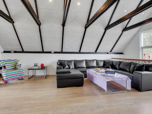 a living room with a black couch and a table at Holiday Home Edith - 1km from the sea by Interhome in Hals