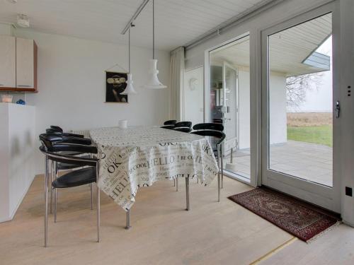 uma sala de jantar com uma mesa e cadeiras pretas em Holiday Home Helja - 125m from the sea in NE Jutland by Interhome em Hals