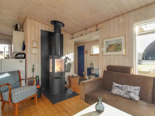 a living room with a woodburning stove in a house at Holiday Home Adi - 75m from the sea in NW Jutland by Interhome in Løkken