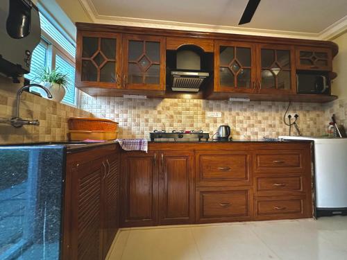 a kitchen with wooden cabinets and a refrigerator at Luxurious 3-bedroom bungalow by the beach in Varca