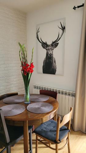 einen Esstisch mit einem Hirschkopf an der Wand in der Unterkunft Borywood in Małe Gacno