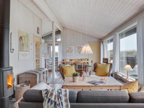 Holiday Home Eri - 300m from the sea in NW Jutland by Interhome في Pandrup: غرفة معيشة مع أريكة وطاولة