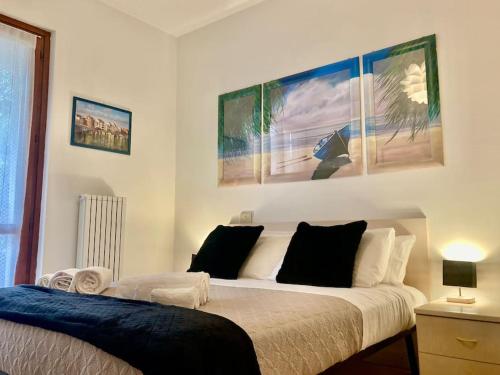 een slaapkamer met twee bedden en twee foto's aan de muur bij Terrazza a pochi passi dal mare in Loano
