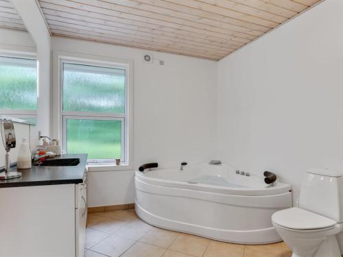 baño blanco con bañera y aseo en Holiday Home Anjetta - from the sea in NE Jutland by Interhome, en Hals