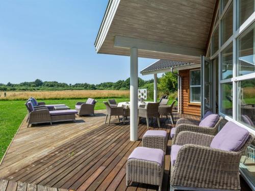 una terraza con sillas y mesas en una casa en Holiday Home Anjetta - from the sea in NE Jutland by Interhome, en Hals
