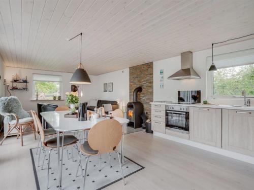 uma cozinha e sala de estar com mesa e cadeiras em Holiday Home Kerttuli - 800m from the sea in NE Jutland by Interhome em Hadsund