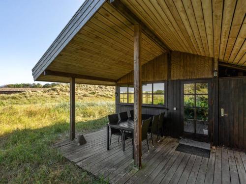 a porch of a house with a table and chairs at Holiday Home Marite - 200m from the sea in NW Jutland by Interhome in Pandrup