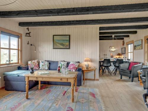 Holiday Home Marite - 200m from the sea in NW Jutland by Interhome في Pandrup: غرفة معيشة مع أريكة زرقاء وطاولة