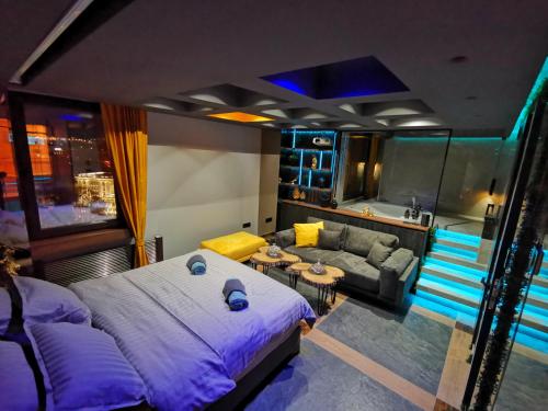 een slaapkamer met een groot bed en een bank bij Smart Luxury Penthouse Suites - Private Sauna, Hot-Tub, Home Cinema at the best Location in Skopje in Skopje