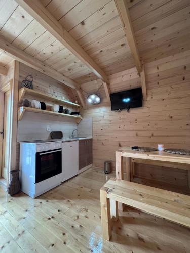 a large kitchen with wooden walls and wooden floors at Brvnare Puljci in Nova Varoš