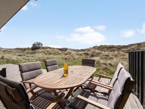 einen Holztisch und Stühle auf einer Terrasse in der Unterkunft Holiday Home Driss - all inclusive - 500m from the sea by Interhome in Pandrup