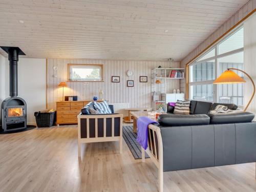 - un salon avec un canapé et une cheminée dans l'établissement Holiday Home Awenita - 50m to the inlet in The Liim Fiord by Interhome, à Løgsted