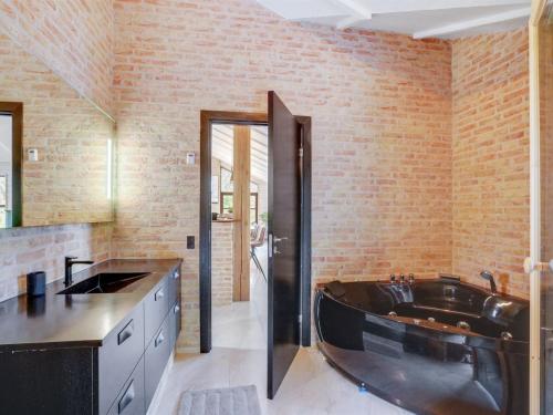a bathroom with a bath tub and a brick wall at Holiday Home Andri - 600m to the inlet in The Liim Fiord by Interhome in Løgstør
