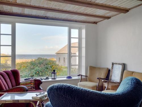 - un salon avec des chaises et une grande fenêtre dans l'établissement Holiday Home Agrippa - 30m to the inlet in The Liim Fiord by Interhome, à Løgstør