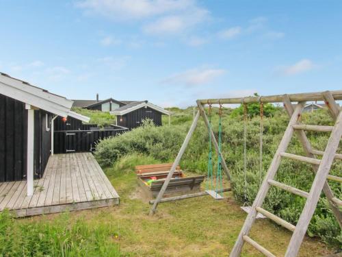 un jardin avec une échelle en bois et une passerelle en bois dans l'établissement Holiday Home Fanija - 200m from the sea in NW Jutland by Interhome, à Hjørring