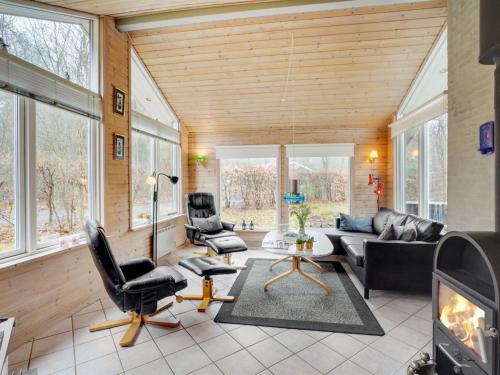 Holiday Home Magh in The Liim Fiord by Interhome في Års: غرفة معيشة مع أريكة وكراسي ومدفأة