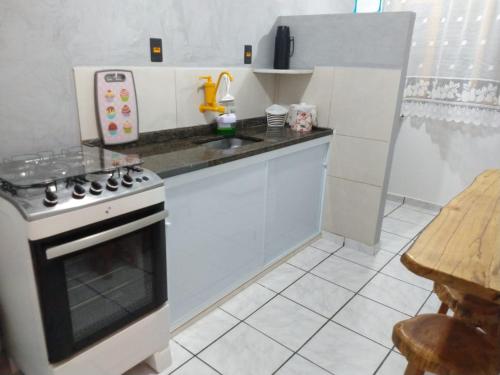 a kitchen with a stove and a counter top at Apartamento novo perto da praia e shoppings in Vila Velha