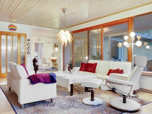a living room with white furniture and red pillows at Holiday Home Sirja - 250m from the sea in NE Jutland by Interhome in Hadsund