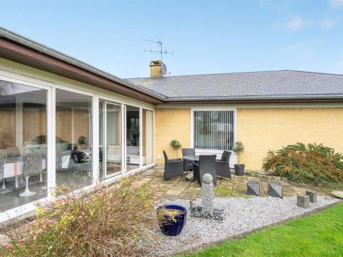 a house with a patio with a table and chairs at Holiday Home Sirja - 250m from the sea in NE Jutland by Interhome in Hadsund