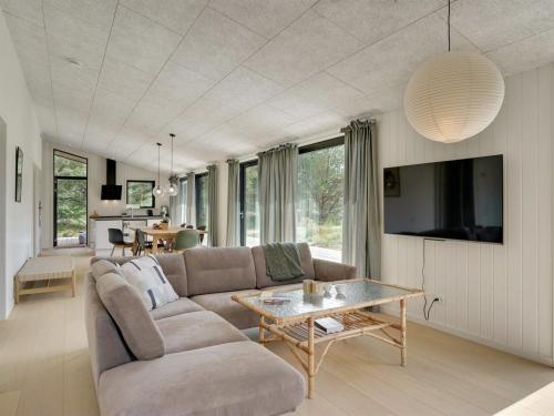 ein Wohnzimmer mit einem Sofa und einem Tisch in der Unterkunft Holiday Home Vigga - 800m from the sea in NW Jutland by Interhome in Fjerritslev