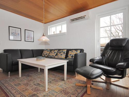 a living room with a couch and a table and a chair at Holiday Home Indi - 400m from the sea by Interhome in Fjerritslev