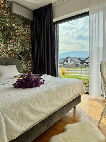a bedroom with a bed and a large window at Apartament Hawkinsa in Jelenia Góra