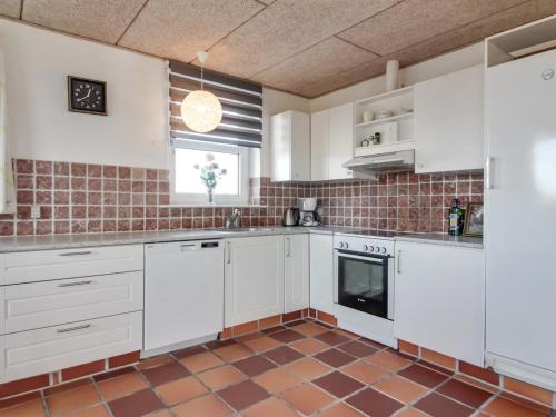 約靈的住宿－Apartment Idolf - 2km from the sea in NW Jutland by Interhome，厨房配有白色橱柜和瓷砖地板。
