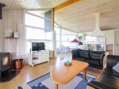 een woonkamer met een bank en een tafel bij Holiday Home Fanni - 300m from the sea in NW Jutland by Interhome in Hjørring