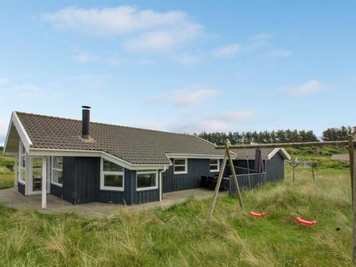 een huis met een blauw huis met een tuin bij Holiday Home Fanni - 300m from the sea in NW Jutland by Interhome in Hjørring