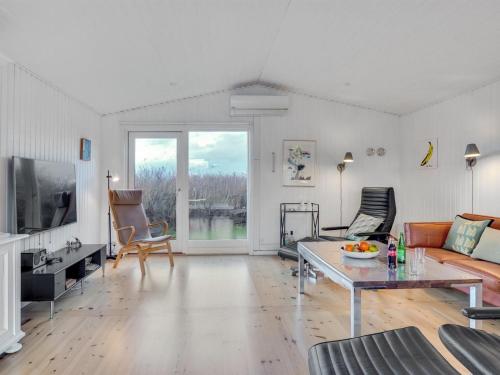 - un salon avec un canapé et une table dans l'établissement Holiday Home Danja - 400m from the sea in NW Jutland by Interhome, à Hjørring