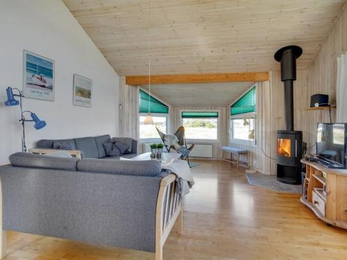 - un salon avec un canapé et une cheminée dans l'établissement Holiday Home Zafirka - 300m from the sea in NW Jutland by Interhome, à Hjørring