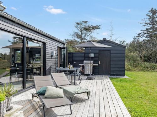une terrasse avec des chaises et un barbecue sur une maison dans l'établissement Holiday Home Talitha - 1-5km from the sea in NW Jutland by Interhome, à Hjørring