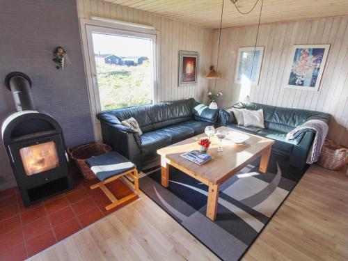 uma sala de estar com um sofá e um fogão a lenha em Holiday Home Vili - all inclusive - 500m from the sea by Interhome em Hirtshals