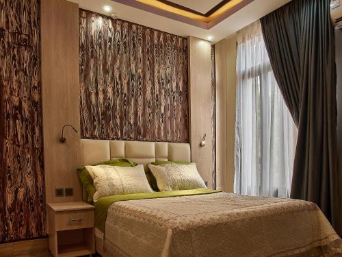 1 dormitorio con cama y ventana grande en Unique Apartment en Kigali