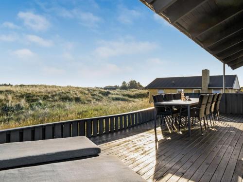 une terrasse en bois avec une table et des chaises. dans l'établissement Holiday Home Fransisca - 600m from the sea in NW Jutland by Interhome, à Bindslev