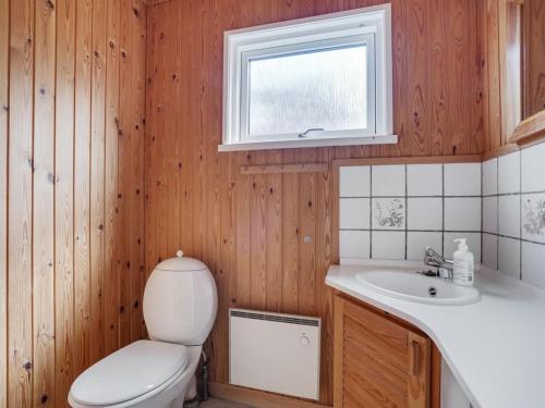 uma casa de banho com um WC, um lavatório e uma janela em Holiday Home Asmara - 200m from the sea in NE Jutland by Interhome em Læsø