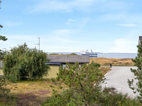 a building with a cruise ship in the distance at Holiday Home Asmara - 200m from the sea in NE Jutland by Interhome in Læsø