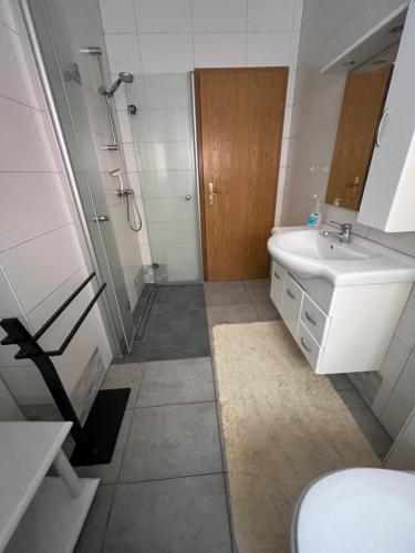 a bathroom with a sink and a shower and a toilet at Ferienwohnung Sandmann in Greifswald