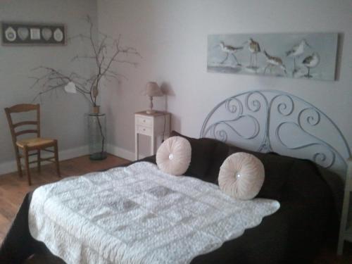 une chambre avec un lit avec deux oreillers dessus dans l'établissement Les Blancarts, à Hautebut