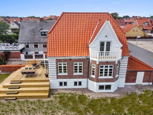 una casa con techo naranja y terraza en Holiday Home Kosara - 50m from the sea in NE Jutland by Interhome, en Frederikshavn