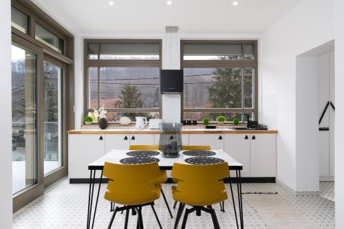 a kitchen with a table and four yellow chairs at szolid in Miskolc