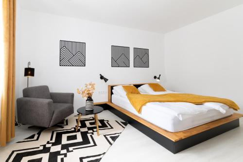 a bedroom with a bed and a chair at szolid in Miskolc