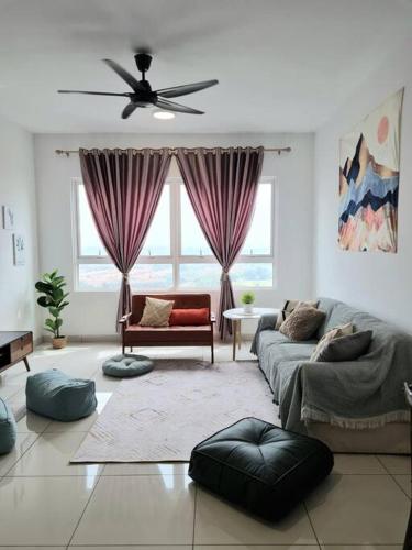 a living room with a couch and a ceiling fan at Impiria Residensi #Link Aeon Mall Klang 4BR3Bath in Klang