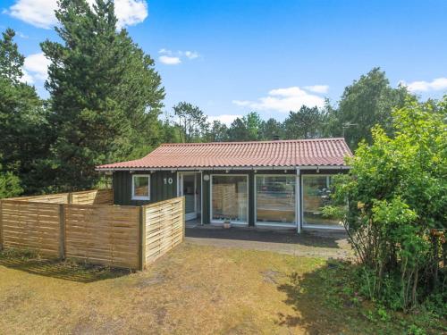 a small house with a wooden fence in a yard at Holiday Home Elmer - 400m from the sea by Interhome in Jerup