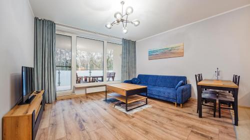 sala de estar con sofá azul y mesa en Apartamenty Sun & Snow Międzyzdroje Aquamarina, en Międzyzdroje