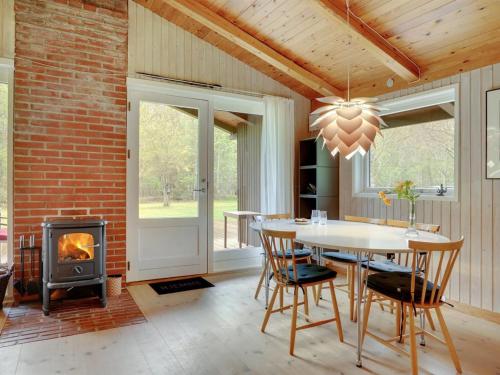a dining room with a table and a wood stove at Holiday Home Thorger - 3km from the sea in NE Jutland by Interhome in Læsø
