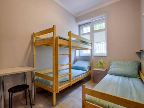sypialnia z 2 łóżkami piętrowymi i biurkiem w obiekcie Najtańsze noclegi w Łodzi